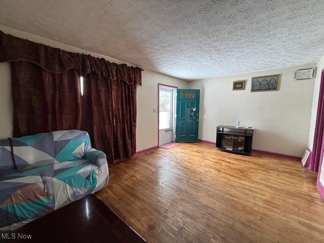 living room with light hardwood / wood-style floors and a textured ceiling