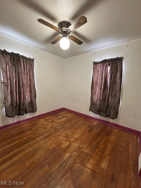 spare room featuring wood-type flooring and ceiling fan