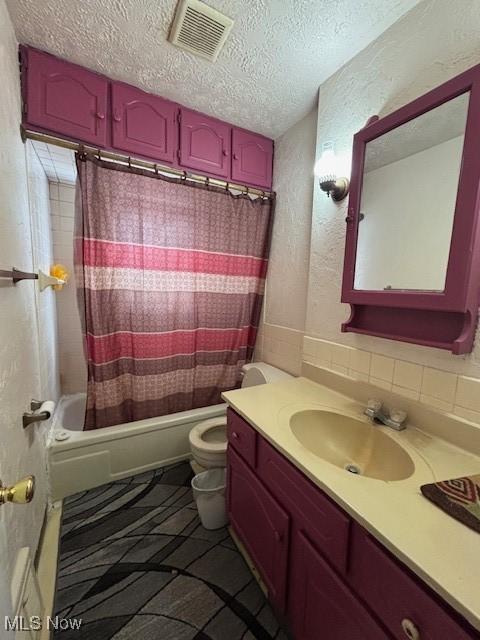 full bathroom with vanity, shower / bath combination with curtain, a textured ceiling, and toilet