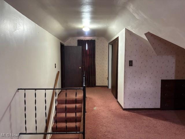 hall with lofted ceiling and carpet