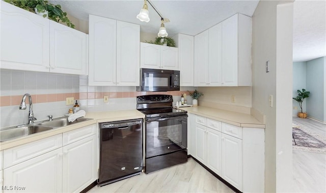 kitchen with sink, white cabinets, decorative backsplash, hanging light fixtures, and black appliances