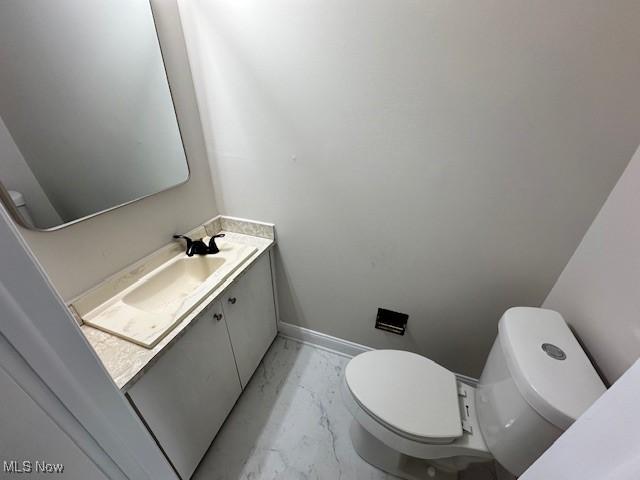 bathroom featuring marble finish flooring, baseboards, toilet, and vanity