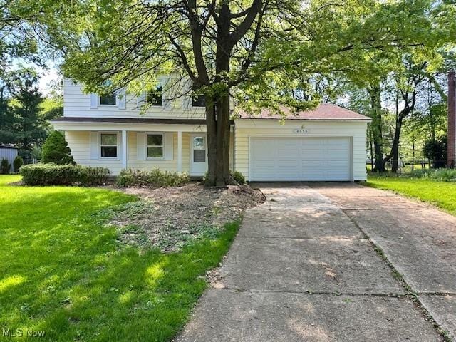 view of front facade with a front yard, driveway, and an attached garage