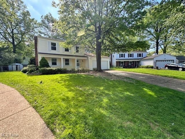traditional-style home featuring asphalt driveway and a front yard