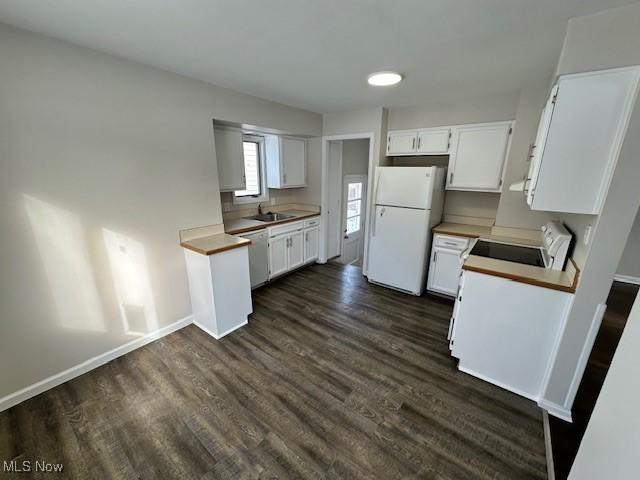 kitchen featuring white cabinetry, sink, white appliances, and dark hardwood / wood-style flooring