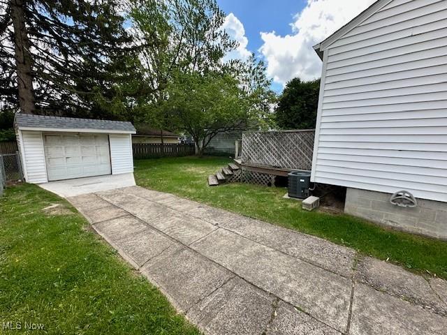5111 Lucydale Ave, North Olmsted, OH 44070 - view of yard with concrete driveway, an outdoor structure, central air condition unit, and a detached garage