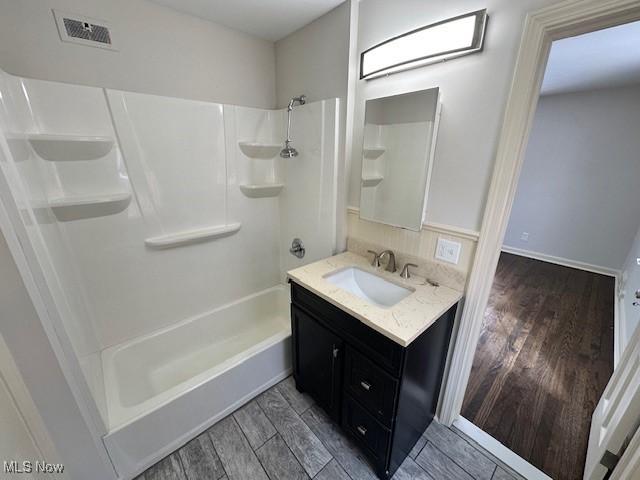 bathroom with vanity and shower / washtub combination