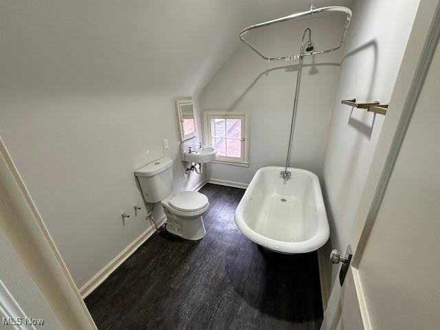 bathroom with a tub to relax in, vaulted ceiling, hardwood / wood-style floors, and toilet