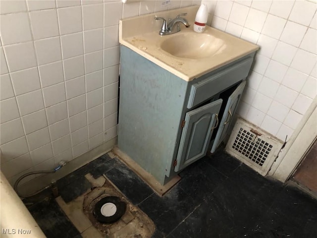 bathroom featuring vanity and tile walls