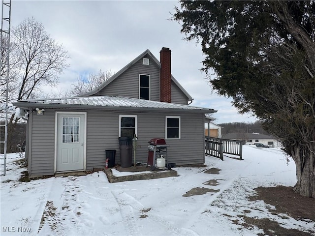 view of snow covered back of property