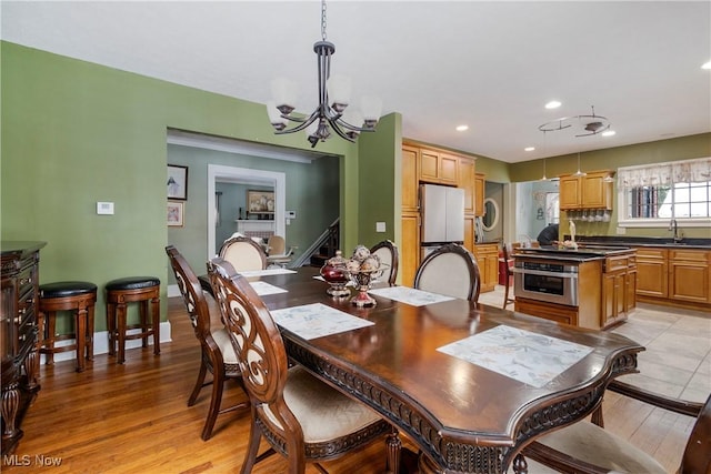 1011 Genesee Dr, Youngstown, OH 44511 - dining space with sink, a chandelier, and light wood-type flooring