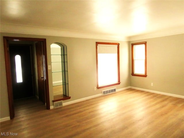 unfurnished room with hardwood / wood-style flooring and ornamental molding