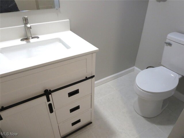 bathroom featuring tile patterned floors, vanity, and toilet