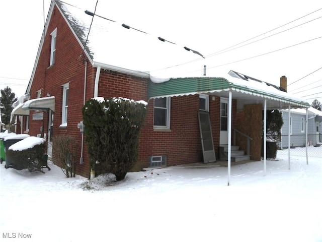 view of snow covered rear of property