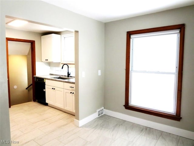 kitchen with a healthy amount of sunlight, sink, and white cabinets