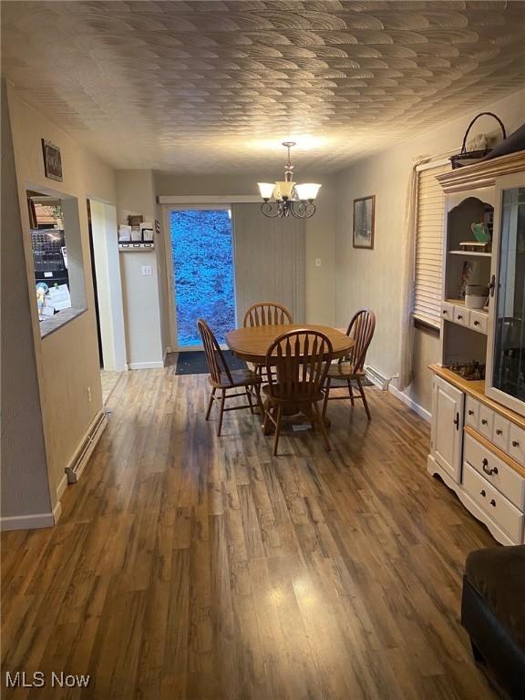 dining area with dark hardwood / wood-style flooring, brick ceiling, and an inviting chandelier