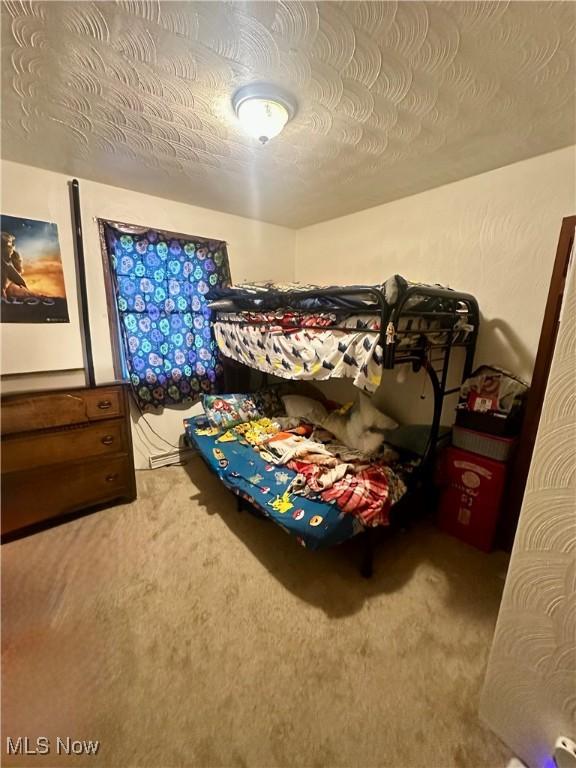 bedroom with a textured ceiling and carpet