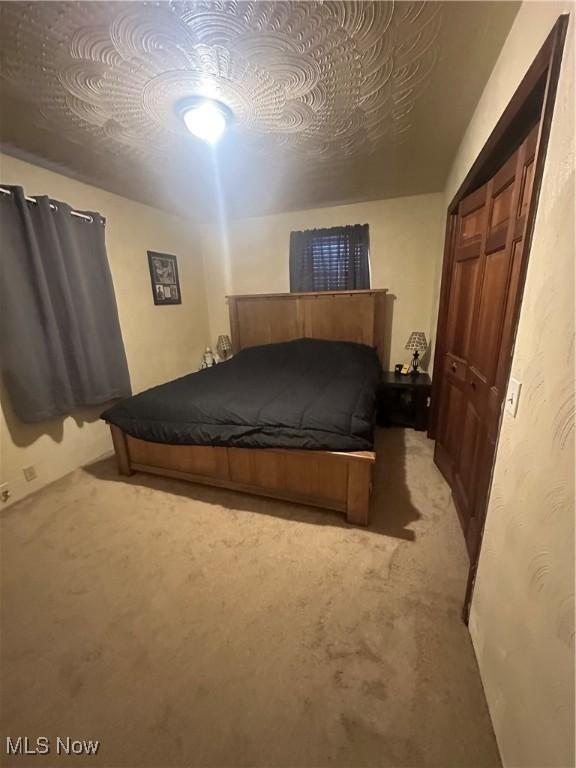 bedroom with light colored carpet and a closet