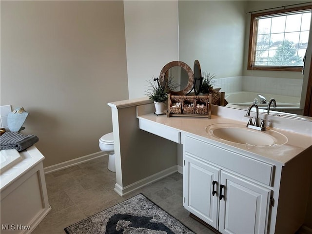 bathroom featuring tile patterned flooring, vanity, a tub to relax in, and toilet