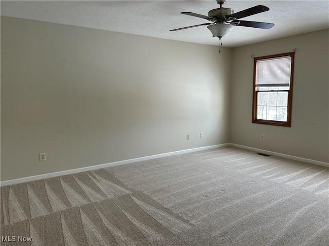 carpeted empty room with a textured ceiling and ceiling fan