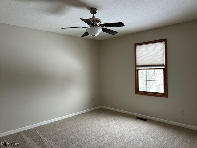 spare room with ceiling fan, a textured ceiling, and carpet