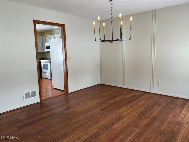 unfurnished dining area with a chandelier and dark hardwood / wood-style flooring