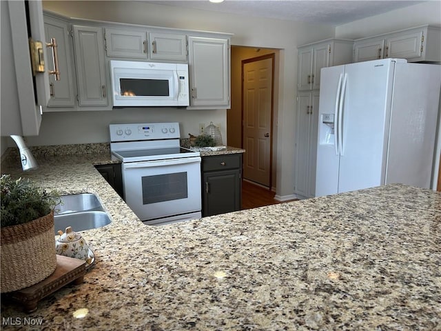 kitchen featuring gray cabinets, light stone countertops, sink, and white appliances