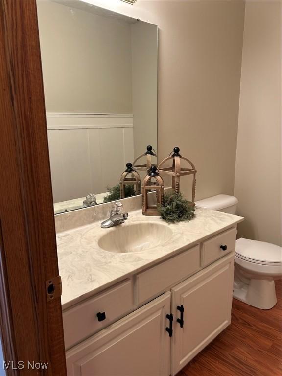 bathroom featuring vanity, wood-type flooring, and toilet