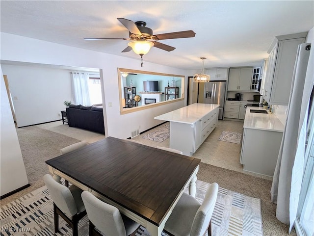 dining room featuring sink and ceiling fan with notable chandelier