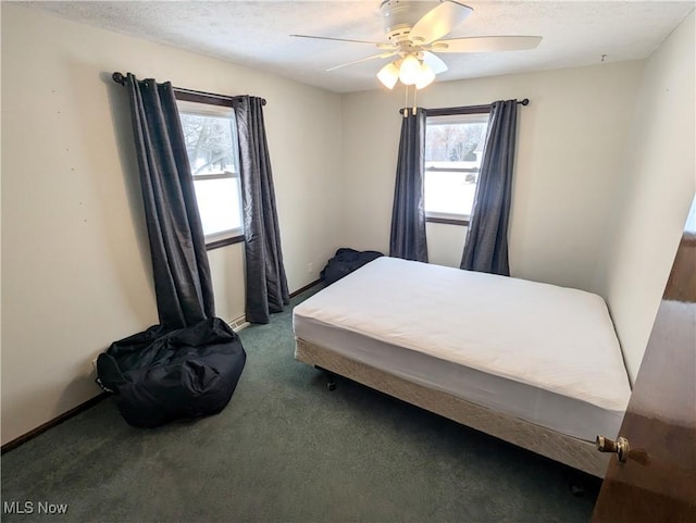 bedroom featuring ceiling fan, a textured ceiling, and dark colored carpet