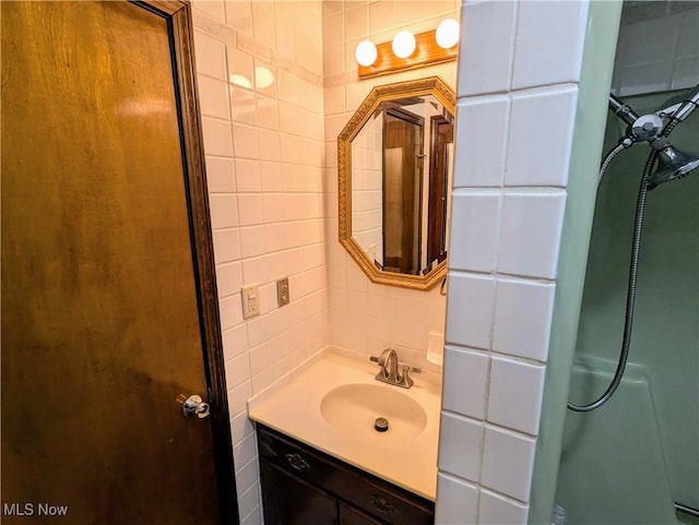 bathroom with vanity, backsplash, a shower, and tile walls