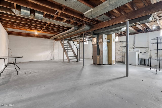 basement featuring washer / dryer, sink, and heating unit