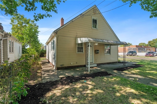 rear view of property featuring a lawn