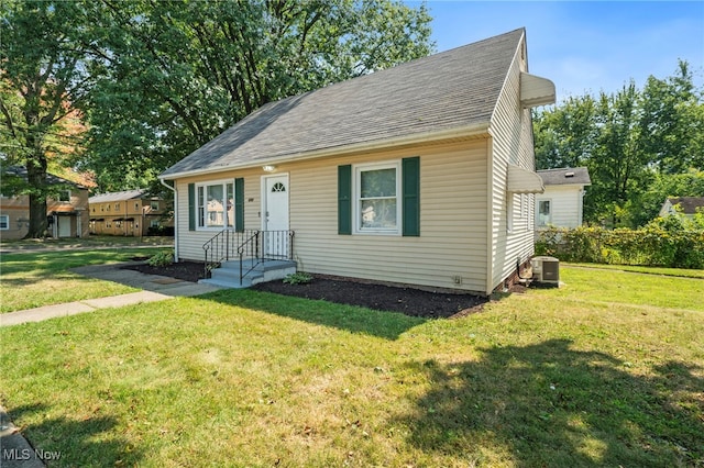 view of front of property featuring central AC and a front yard