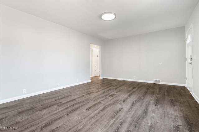 spare room with dark wood-type flooring