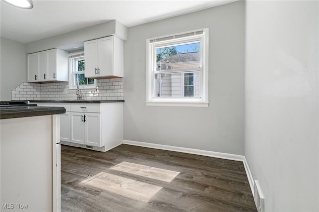 kitchen featuring backsplash, dark hardwood / wood-style floors, sink, and white cabinets