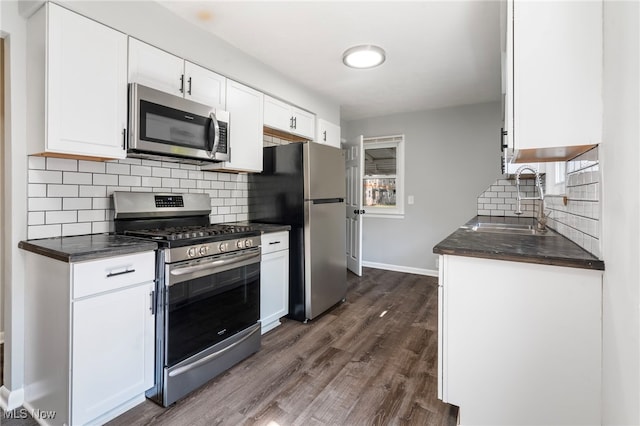 kitchen featuring sink, stainless steel appliances, dark hardwood / wood-style floors, tasteful backsplash, and white cabinets