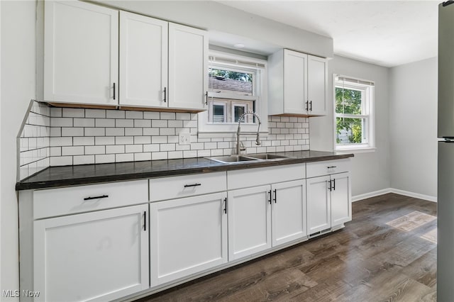 kitchen with tasteful backsplash, sink, white cabinets, and dark hardwood / wood-style floors