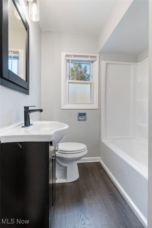 full bathroom featuring vanity, hardwood / wood-style floors, bathtub / shower combination, and toilet