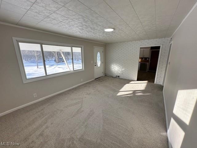 carpeted spare room featuring baseboards