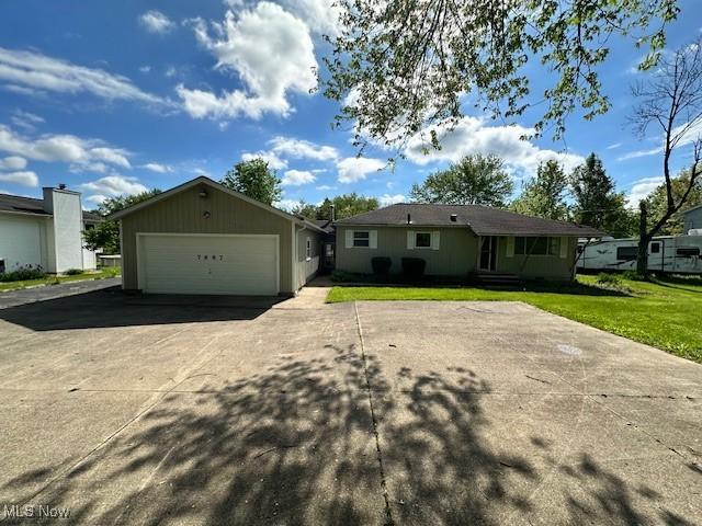 view of front of home with concrete driveway, a garage, and a front lawn