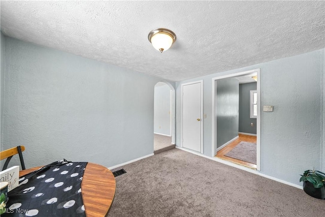 unfurnished bedroom featuring carpet flooring and a textured ceiling