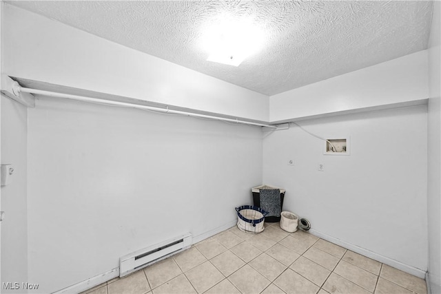 clothes washing area with hookup for a washing machine, a baseboard heating unit, light tile patterned floors, and a textured ceiling