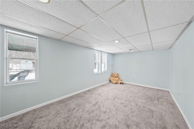 basement featuring a drop ceiling and carpet floors