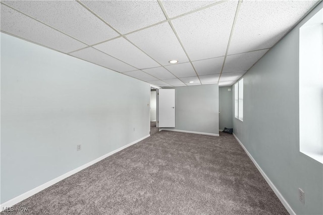 basement with carpet floors and a paneled ceiling