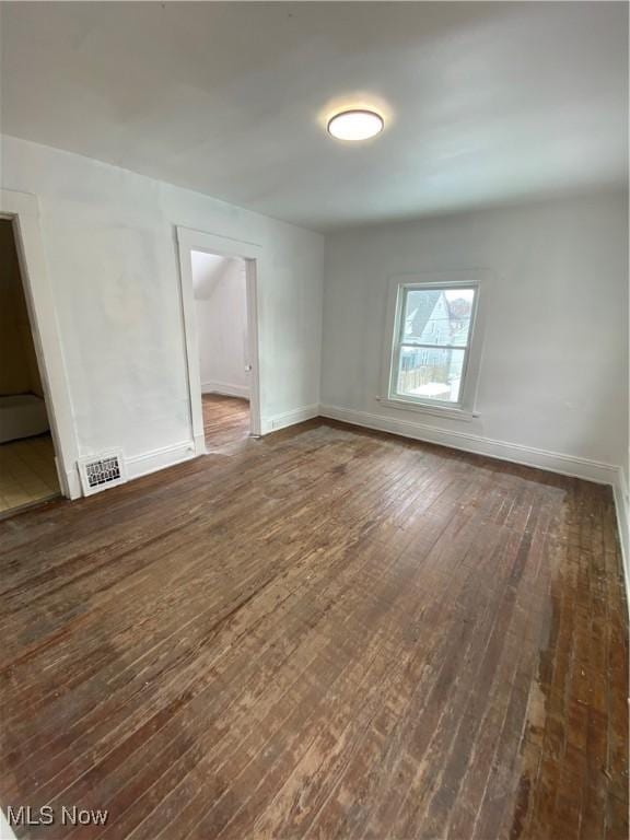 empty room with dark wood-type flooring