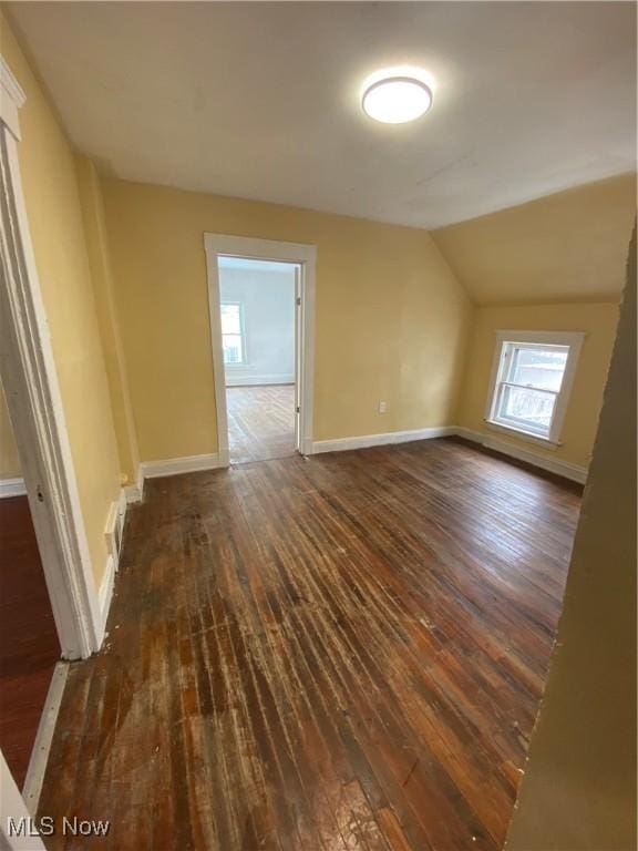 additional living space with lofted ceiling and dark hardwood / wood-style floors