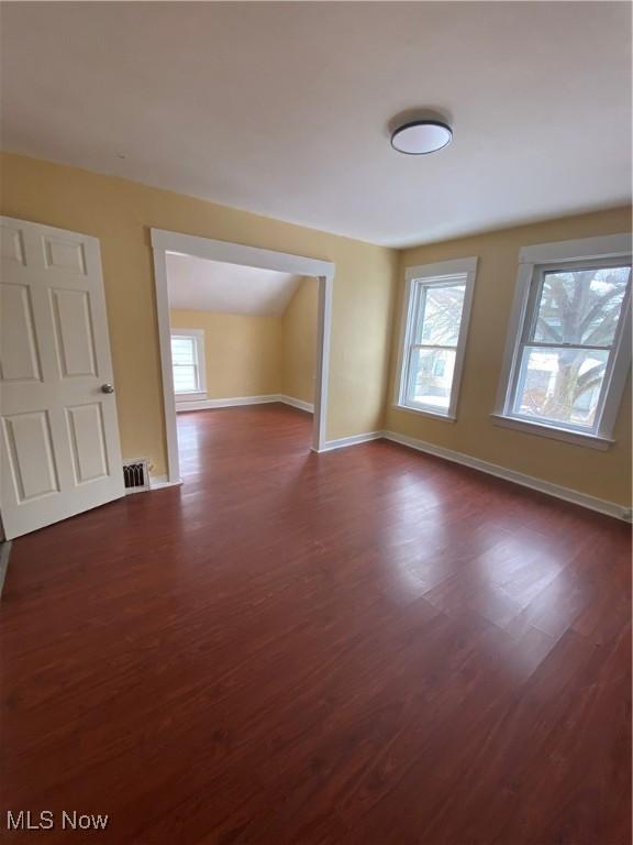 unfurnished room with plenty of natural light and dark hardwood / wood-style floors