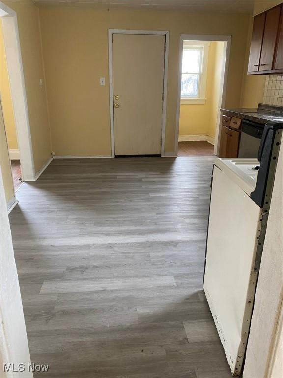 interior space featuring tasteful backsplash, stainless steel dishwasher, light hardwood / wood-style floors, and range