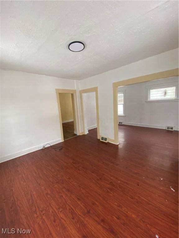 unfurnished room with dark wood-type flooring